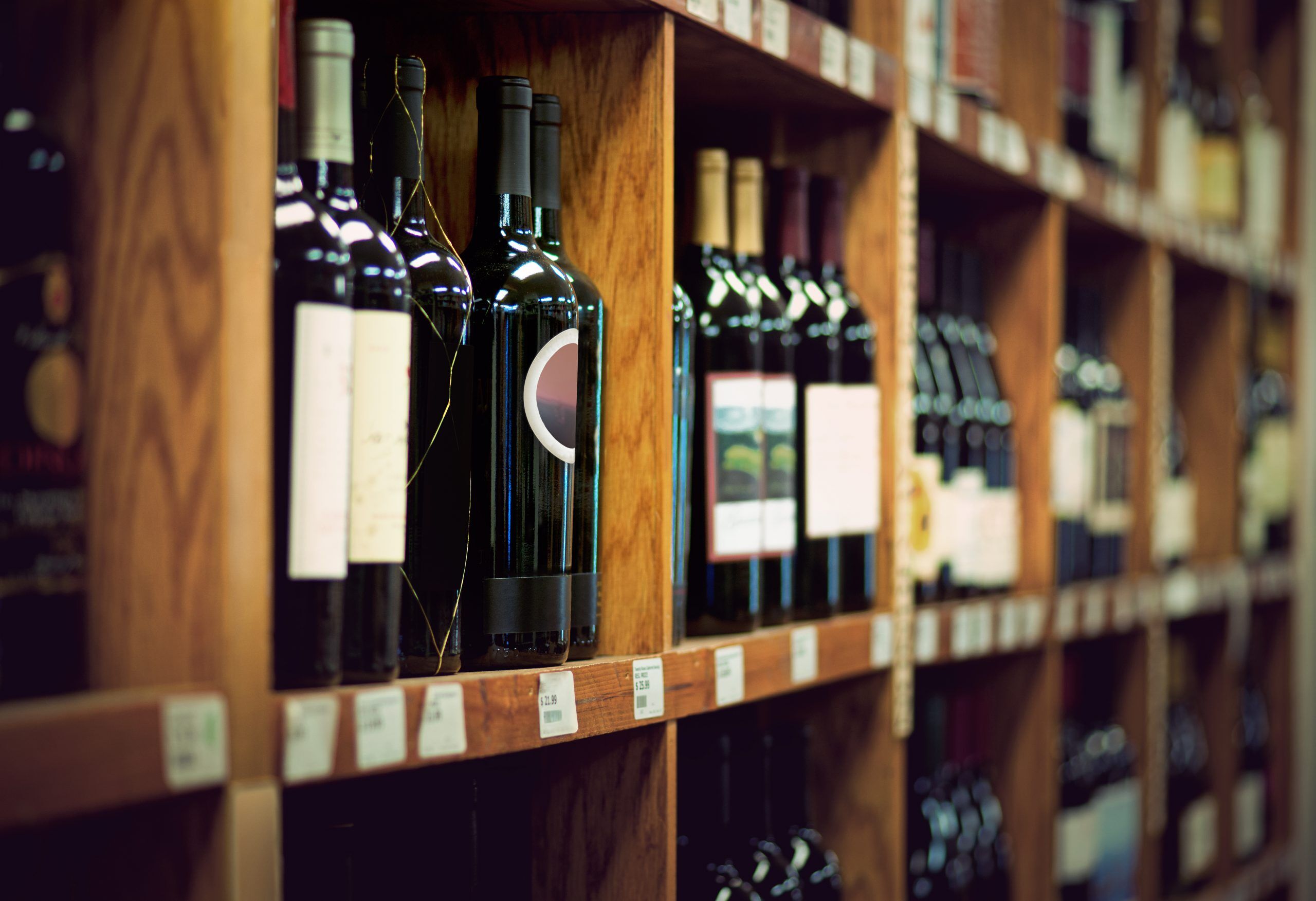 Wine bottles on wooden shelf in wine store